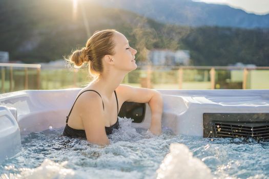 Portrait of young carefree happy smiling woman relaxing at hot tub during enjoying happy traveling moment vacation life against the background of green big mountains.