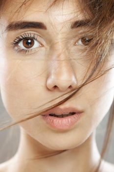 Beautiful brunette girl studio portrait. Serious face expression.