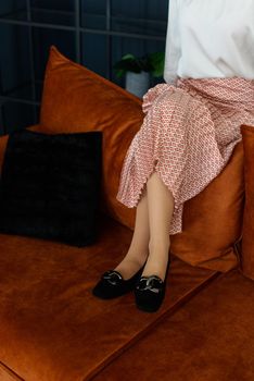 Photo of a womens legs in suede high-heeled shoes with a buckle. Selective focus