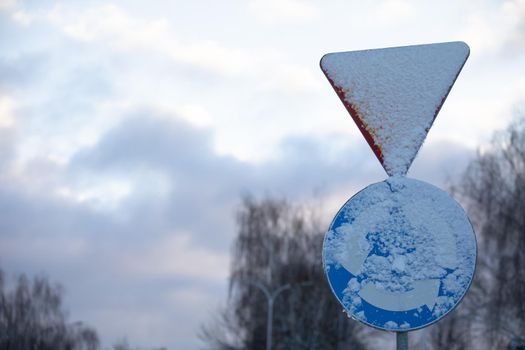 Two traffic signs, one is a traffic circle intersection or traffic circle and the other is give way.