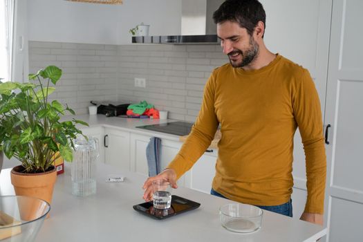 young bearded man making artisan bread in his home kitchen