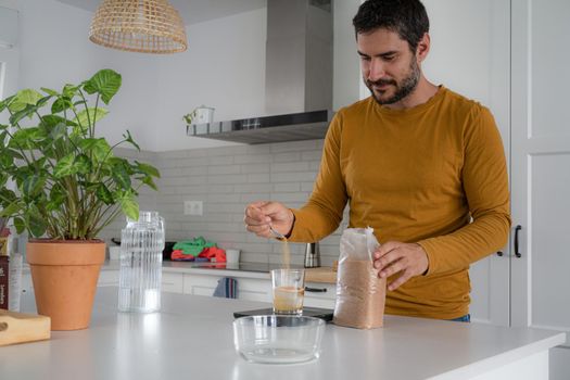 young bearded man making artisan bread in his home kitchen