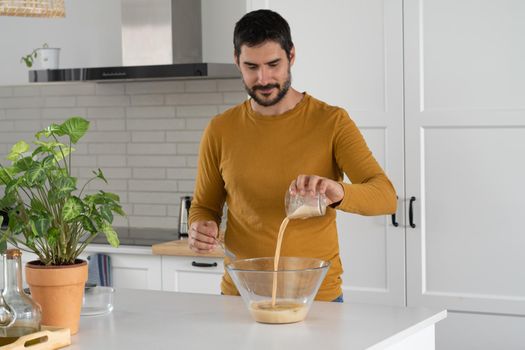 young bearded man making artisan bread in his home kitchen