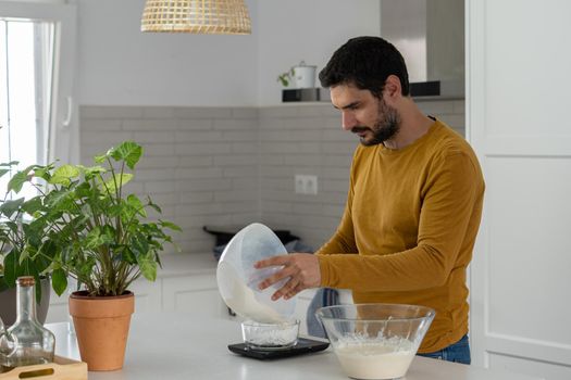 young bearded man making artisan bread in his home kitchen