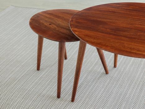 Double wooden table on carpet in interior of a living room or hotel. Empty surface furniture of brown color