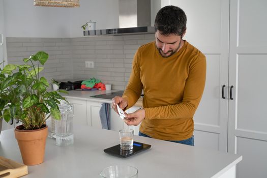 young bearded man making artisan bread in his home kitchen