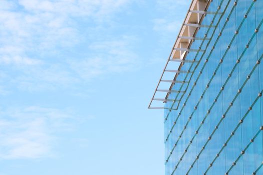 A modern glass building against a blue sky