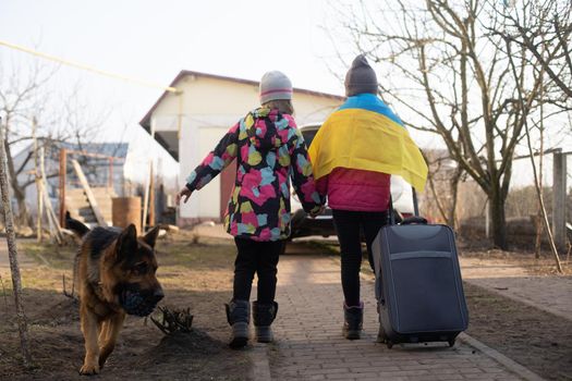 two little girls with the flag of ukraine, suitcase, dogs. Ukraine war migration. Collection of things in a suitcase. Flag of Ukraine, help. Krizin, military conflict