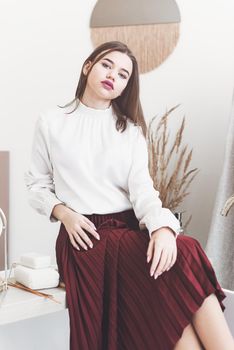 Portrait of fashionable women in red skirt and white blouse posing in a bath. Girl with a big red lips