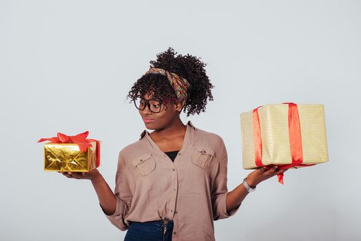 Small one for the kids and big one for adults. Holidays and celebration conception. Beautiful afro american girl with curly hair in the studio with white background.