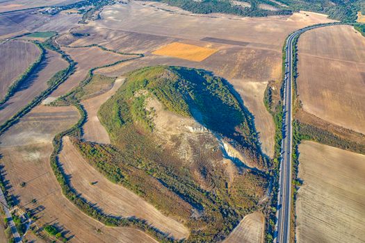 ?erial view from drone of beautiful countryside with big hill, fields and road