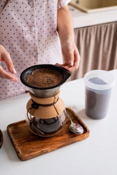 Alternative coffee brewing. young woman in lovely pajamas making coffee at home kitchen