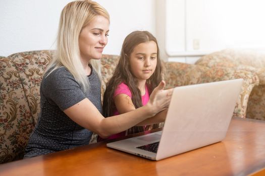 Happy family Mother and daughter watching videe entertainment with laptop computer technology the living room enjoy life at home concept.