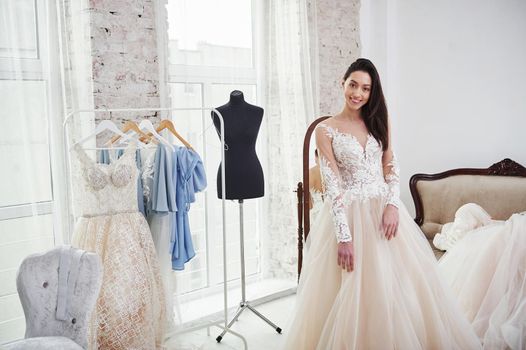 Satisfied smile. The process of fitting the dress in the studio of hand crafted clothes.