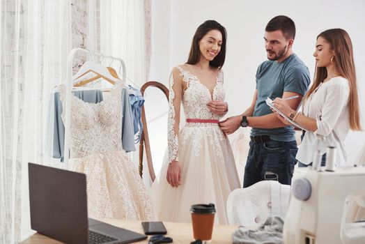 Girl is satisfied. The process of fitting the dress in the studio of hand crafted clothes.