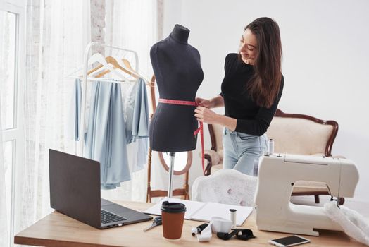Nice mood. Female fashion designer works on the new clothes in the workshop.