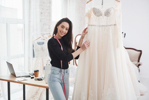 This satisfied moment whe you done your work perfectly. Female fashion designer works on the new clothes in the workshop.