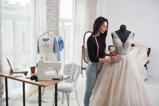 Perfect for nice waist. Female fashion designer works on the new clothes in the workshop.