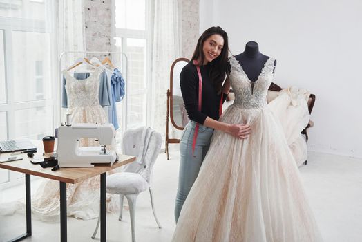 Look at her creation. Female fashion designer works on the new clothes in the workshop.