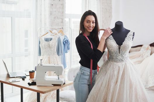 After hard job. Female fashion designer works on the new clothes in the workshop.