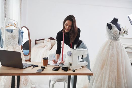 Modern room. Female fashion designer works on the new clothes in the workshop.