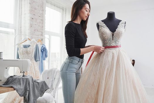 Concentrating at job. Female fashion designer works on the new clothes in the workshop.