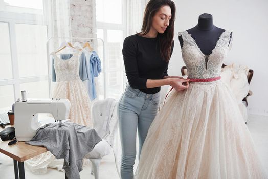 Just to make sure that everything is good. Female fashion designer works on the new clothes in the workshop.