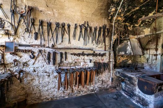 old forge with many instruments on the wall