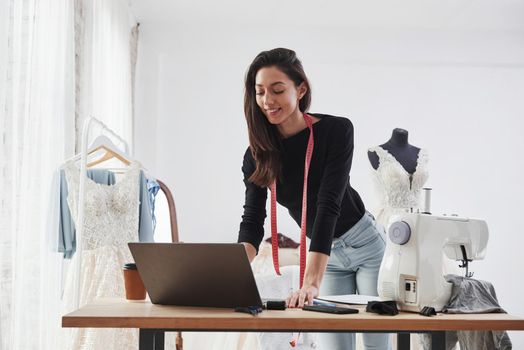 Received positive response. Female fashion designer works on the new clothes in the workshop.