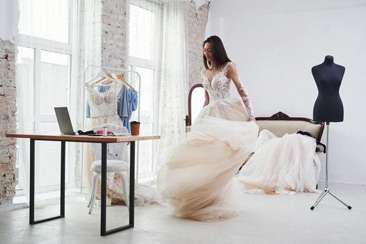 Rolling around herself. The process of fitting the dress in the studio of hand crafted clothes.