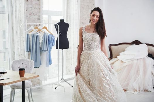 Bride is ready for the action. The process of fitting the dress in the studio of hand crafted clothes.