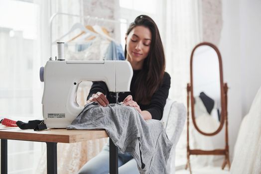 Fully concentrated at her job. Female fashion designer works on the new clothes in the workshop.