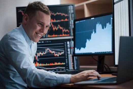 Thinks what to do next. Man working online in the office with multiple computer screens in index charts.