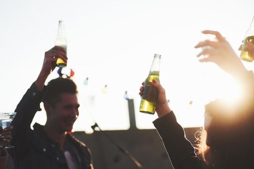 Hands in the air. It's rooftop party. Group of friends have holidays at sunny autumn day.