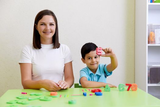 Children practice correct pronunciation with female speech therapist