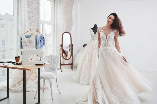 Bride is ready for her wedding. The process of fitting the dress in the studio of hand crafted clothes.