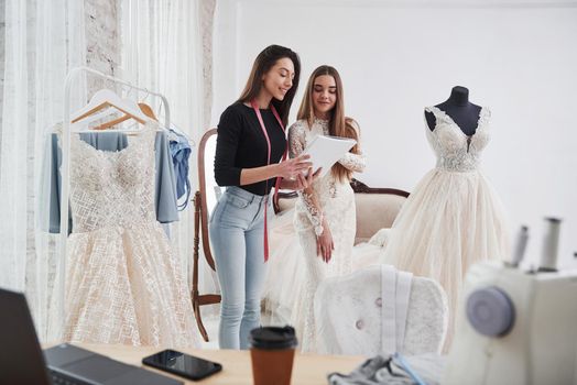 Shows the sizes. The process of fitting the dress in the studio of hand crafted clothes.