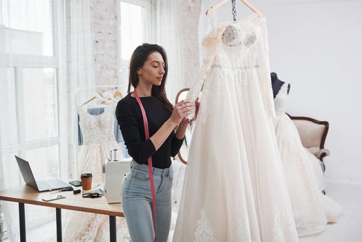 Smartphones and laptop on the table. Female fashion designer works on the new clothes in the workshop.