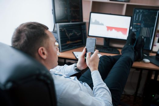 Business owner. Man working online in the office with multiple computer screens in index charts.