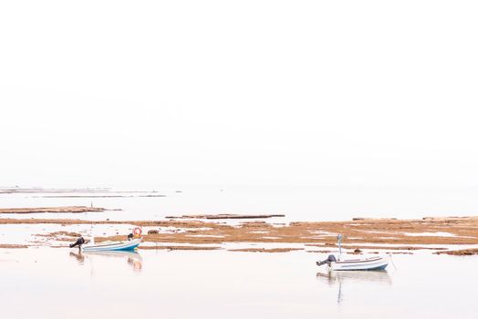A small fishing boat on the beach in Jaffa, on a foggy day. Concept for peace, quiet and serenity. High key photography. High quality photo