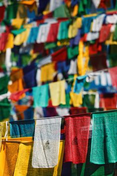 Buddhist prayer flags lungta with Om Mani Padme Hum Buddhist mantra prayer meaning Praise to the Jewel in the Lotus on kora around Tsuglagkhang complex. McLeod Ganj, Himachal Pradesh, India