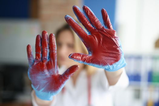 Bloodied hand in doctor medical gloves in clinic. Bleeding and methods to stop it concept