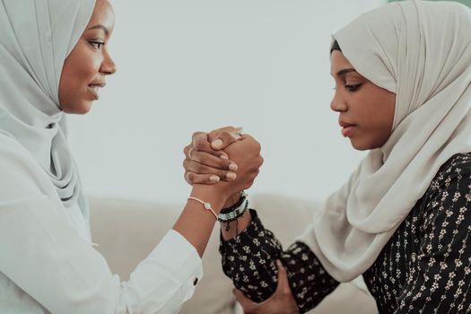 African women arm wrestling conflict concept, disagreement, and confrontation wearing traditional Islamic hijab clothes. Selective focus. High-quality photo