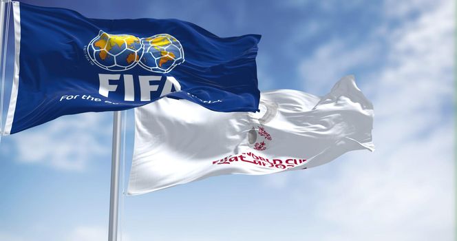 Doha, Qatar, January 2022: Flags with FIFA and Qatar 2022 World Cup logo waving in the wind. The event is scheduled in Qatar from 21 November to 18 December 2022