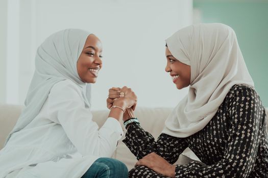African women arm wrestling conflict concept, disagreement, and confrontation wearing traditional Islamic hijab clothes. Selective focus. High-quality photo
