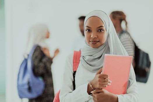 African female student with a group of friends in the background wearing traditional Islamic hijab clothes. Selective focus. High-quality photo