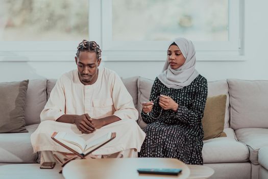 African Muslim couple at home in Ramadan reading Quran holly Islam book. High-quality photo
