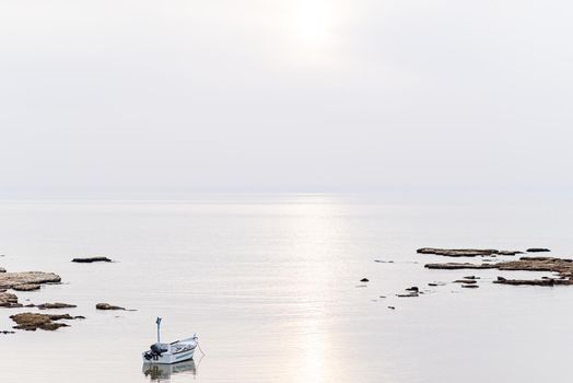 A small fishing boat on the beach in Jaffa, on a foggy day. Concept for peace, quiet and serenity. High key photography. High quality photo