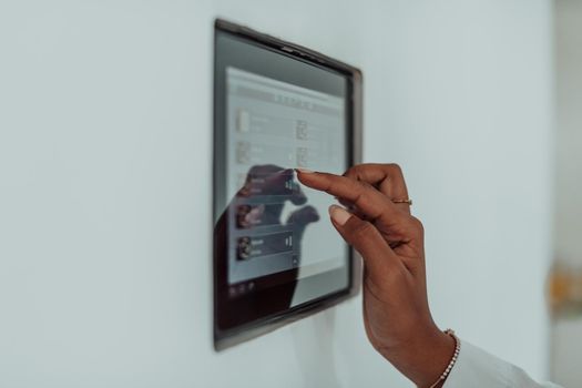 African woman using a smart home screen control system. High-quality photo