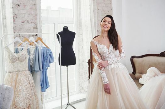 Smiling to the camera. The process of fitting the dress in the studio of hand crafted clothes.